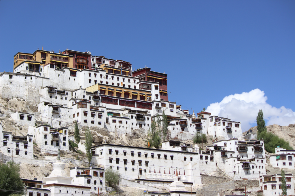 A breathtaking front view of Thiksey Monastery in Leh, Ladakh, showcasing its multi-tiered Tibetan architecture set against the rugged Himalayan landscape.